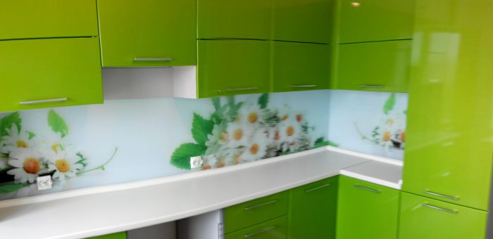 Угловая кухня с зелеными фасадами и стеклянным фартуком
